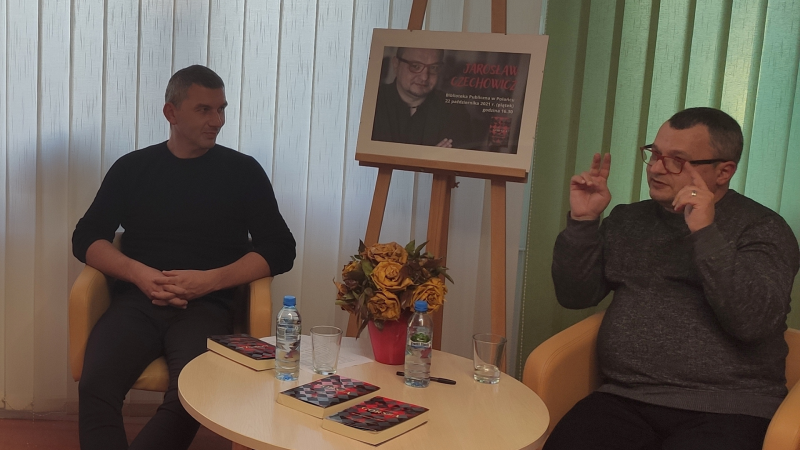 Zdjęcie kolorowe, spotkanie autorskie z Jarosławem Czechowiczem w Bibliotece, na zdjęciu autor i prowadzący spotkanie Marek Pedyński