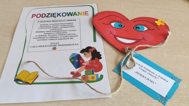 Zdjęcie kolorowe, przedszkolaki z życzeniami z okazji dnia bibliotekarza w bibliotece