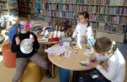 Zdjęcie kolorowe, dzieci bawiące się w bibliotece podczas ferii zimowych