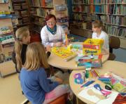 Zdjęcie kolorowe, dzieci bawiące się w bibliotece podczas ferii zimowych